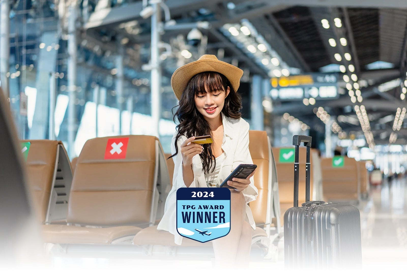 young-woman-using-credit-card-on-smartphone-at-airport-terminal_Twenty47studio